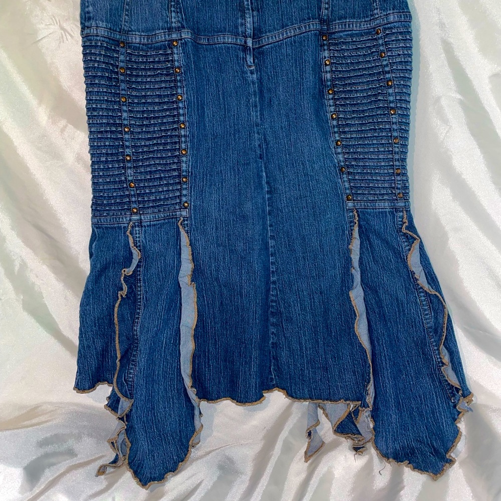 Intentionally distressed midi
jean skirt with cool ruffles at the bottom.